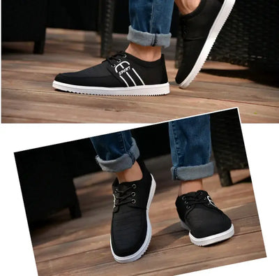 Men's breathable casual sneakers in black with white soles, designed for comfort and style on wooden surface.