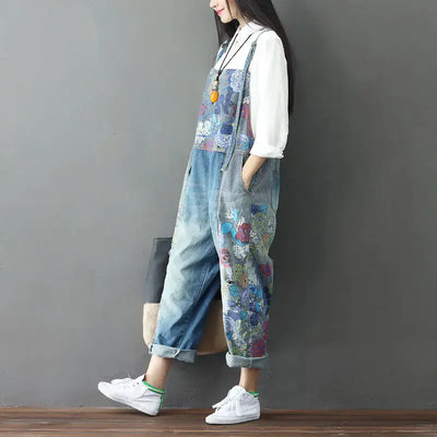 A woman wearing vintage patchwork jeans with a floral design, paired with a white top and sneakers, showcasing casual streetwear style.