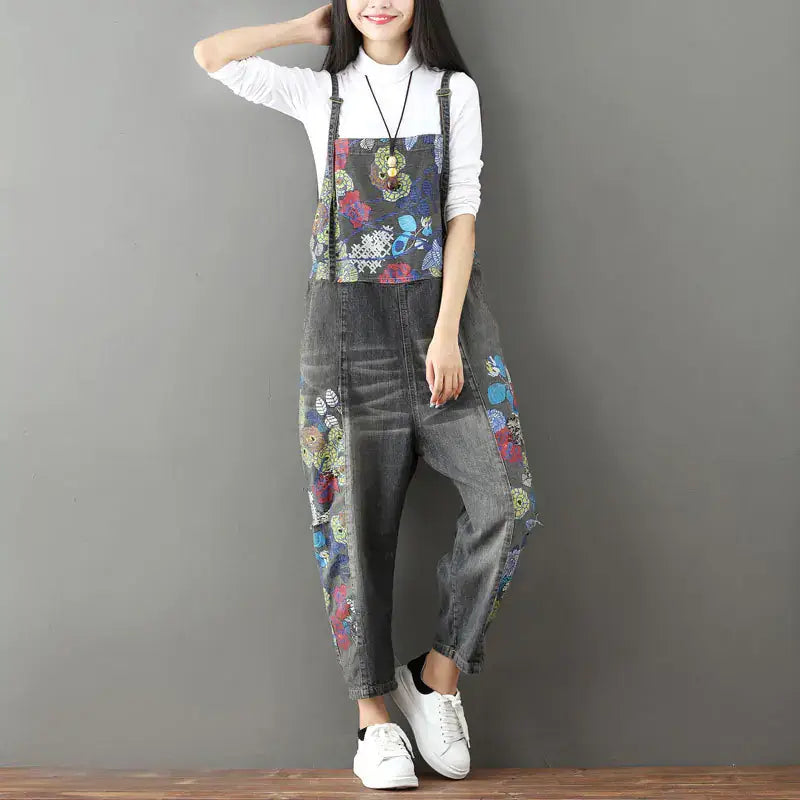 Woman wearing vintage patchwork denim overalls featuring colorful designs, styled with a casual white tee and sneakers.