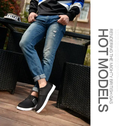 Men's breathable casual sneakers paired with blue jeans, showcased in a stylish outdoor setting.