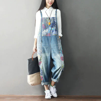 Woman wearing vintage patchwork denim overalls with a floral design, paired with a white shirt and sneakers.