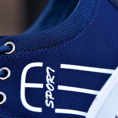 Close-up of navy blue men's breathable casual sneaker featuring mesh design and sport branding.